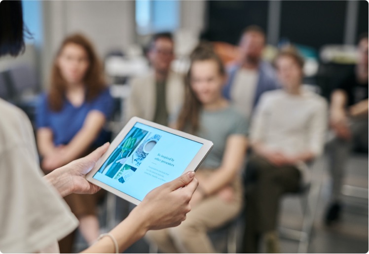 a speaker referencing their notes before an attentive group